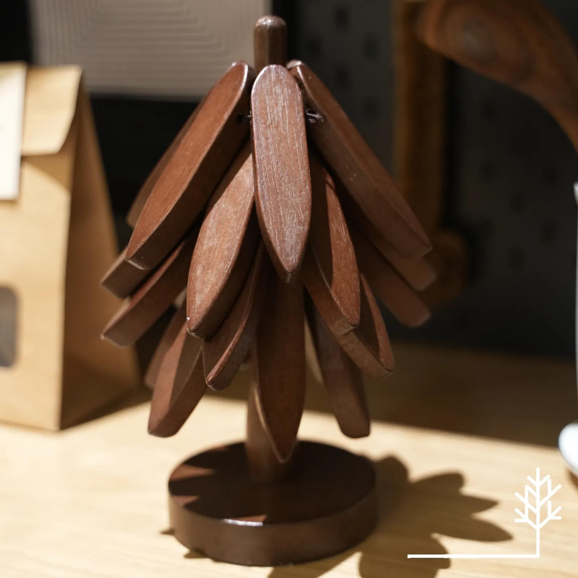 Foldable tree trivet doubles as a pot holder for hot dishes.