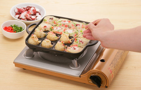 Iwatani Takoyaki grill pan handle close-up for secure grip during cooking.