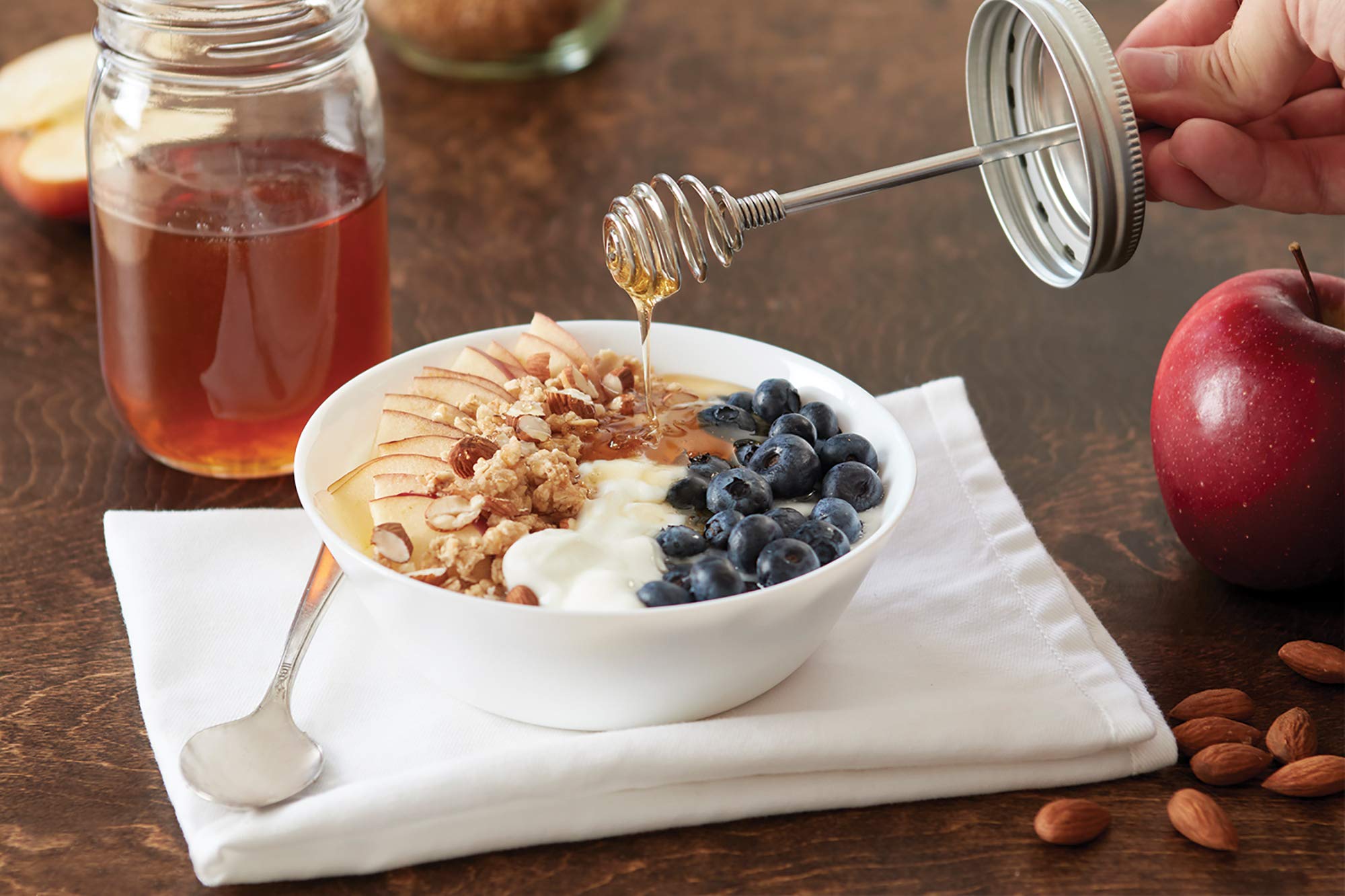 Jarware honey dipper lid dispensing honey with controlled drizzle.
