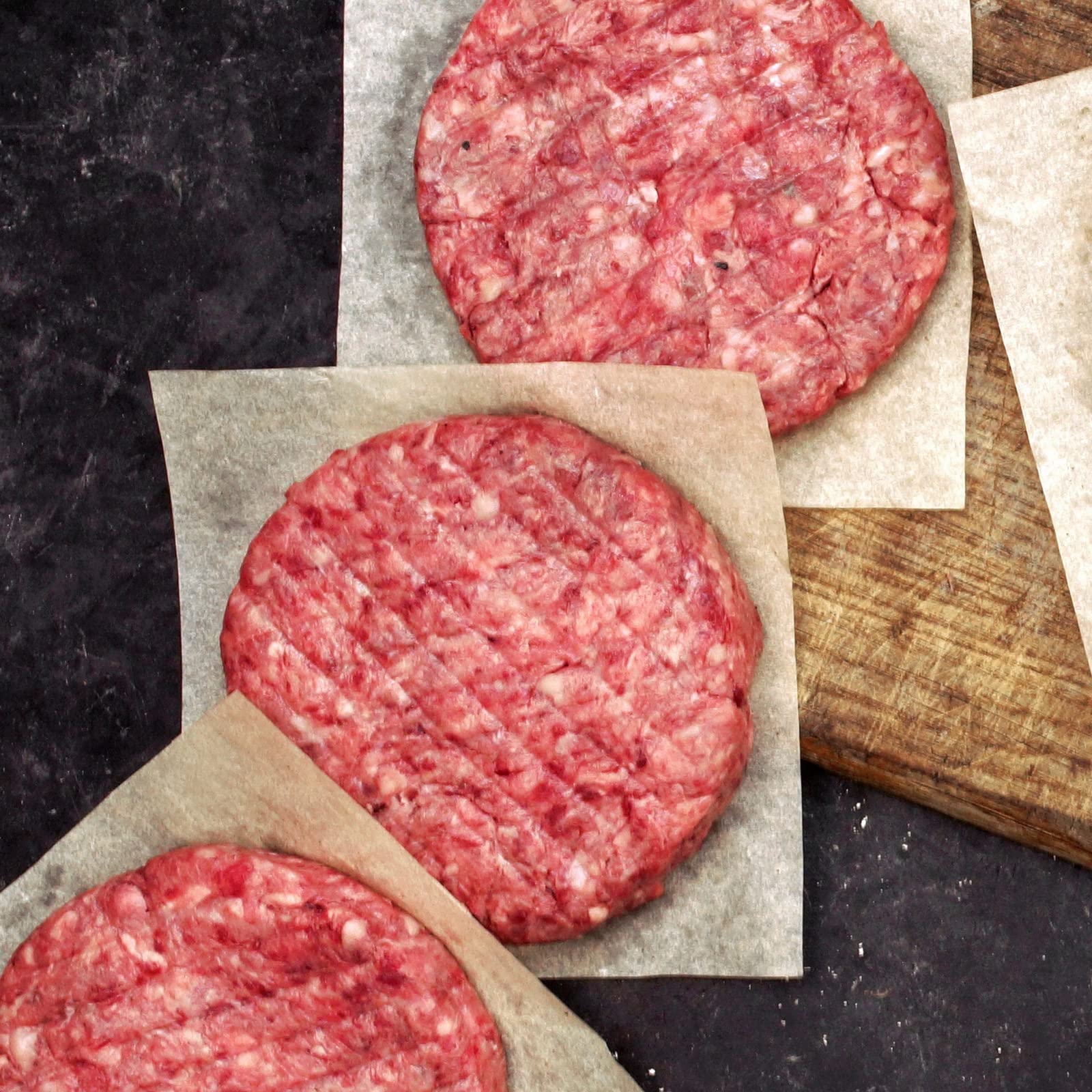 Juvale parchment sheets keep hamburger patties separated, preventing sticking during prep.