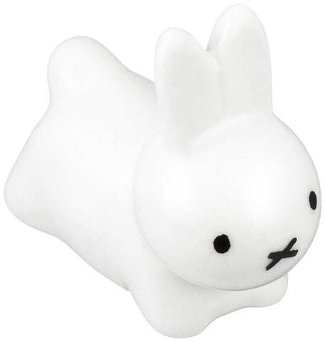 Kaneshotouki Miffy rabbit chopstick rest in white porcelain holding chopsticks.