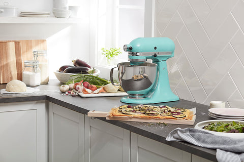 KitchenAid Artisan mixer on a counter, showcasing comfortable handle and spacious bowl.