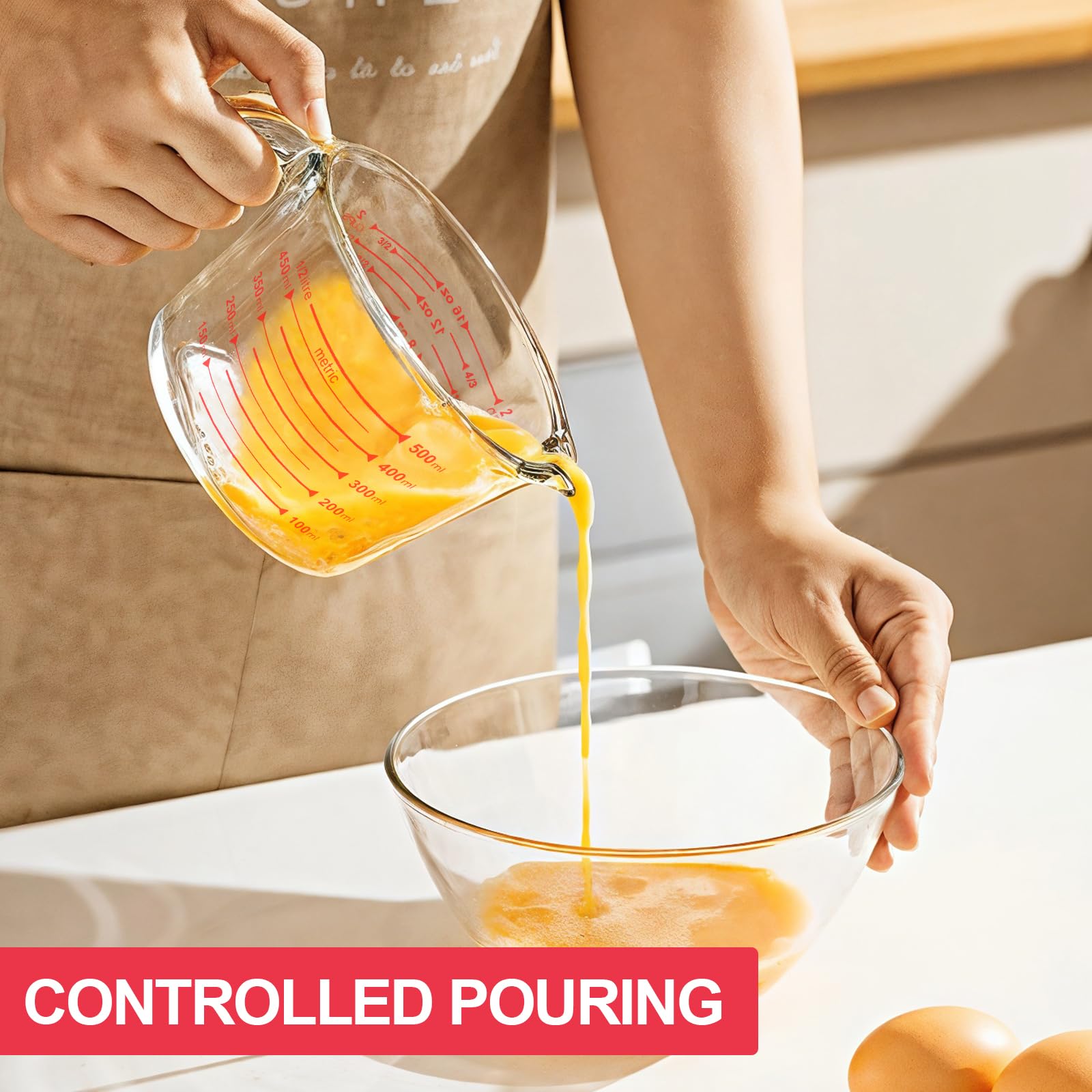 KOMUEE glass measuring cups with lids demonstrating spill-free pouring.