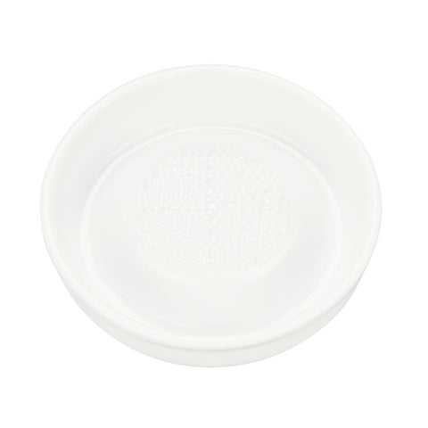 KYOCERA 3.5-inch ceramic grater shredding ginger for fresh flavor and aroma.
