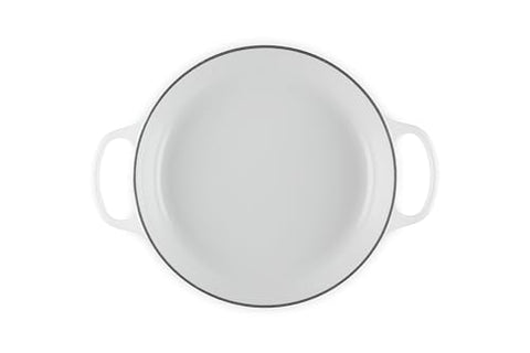 Le Creuset braiser interior with white enamel for easy monitoring.