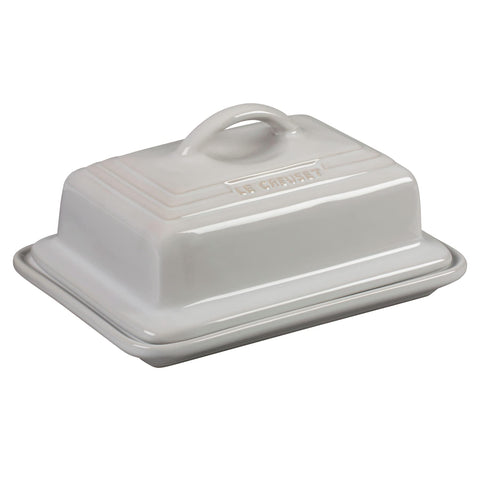 Le Creuset butter dish on counter showing two-stick capacity and white finish.