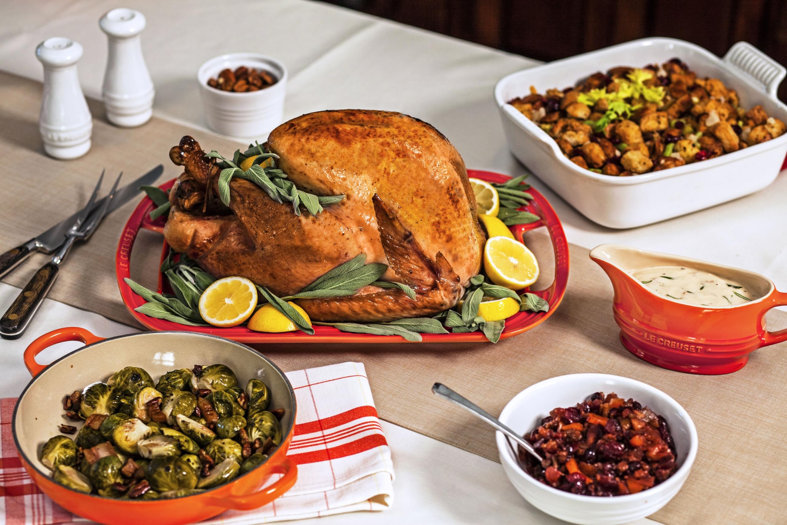 Le Creuset white shakers pairing with other stoneware for cohesive kitchen style.