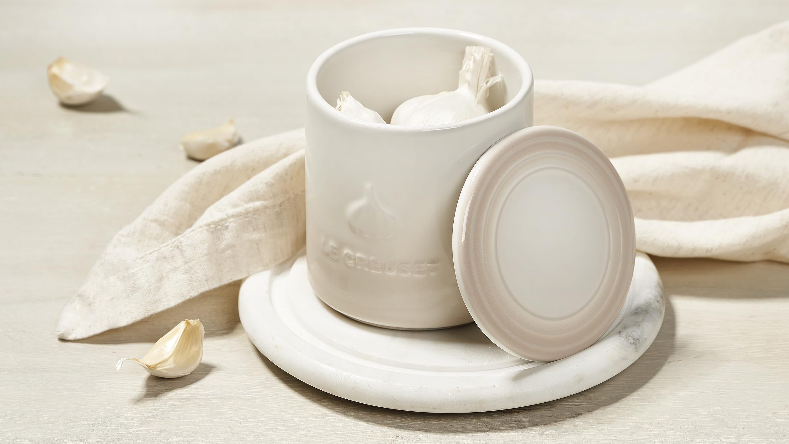 Le Creuset garlic keeper on counter, convenient storage and display.