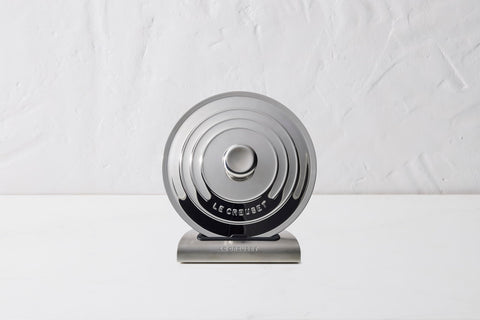Le Creuset lid holder folds flat for compact storage in cupboard