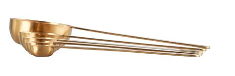 Le Creuset gold measuring spoons show 1-4-tsp scale for consistent portions.