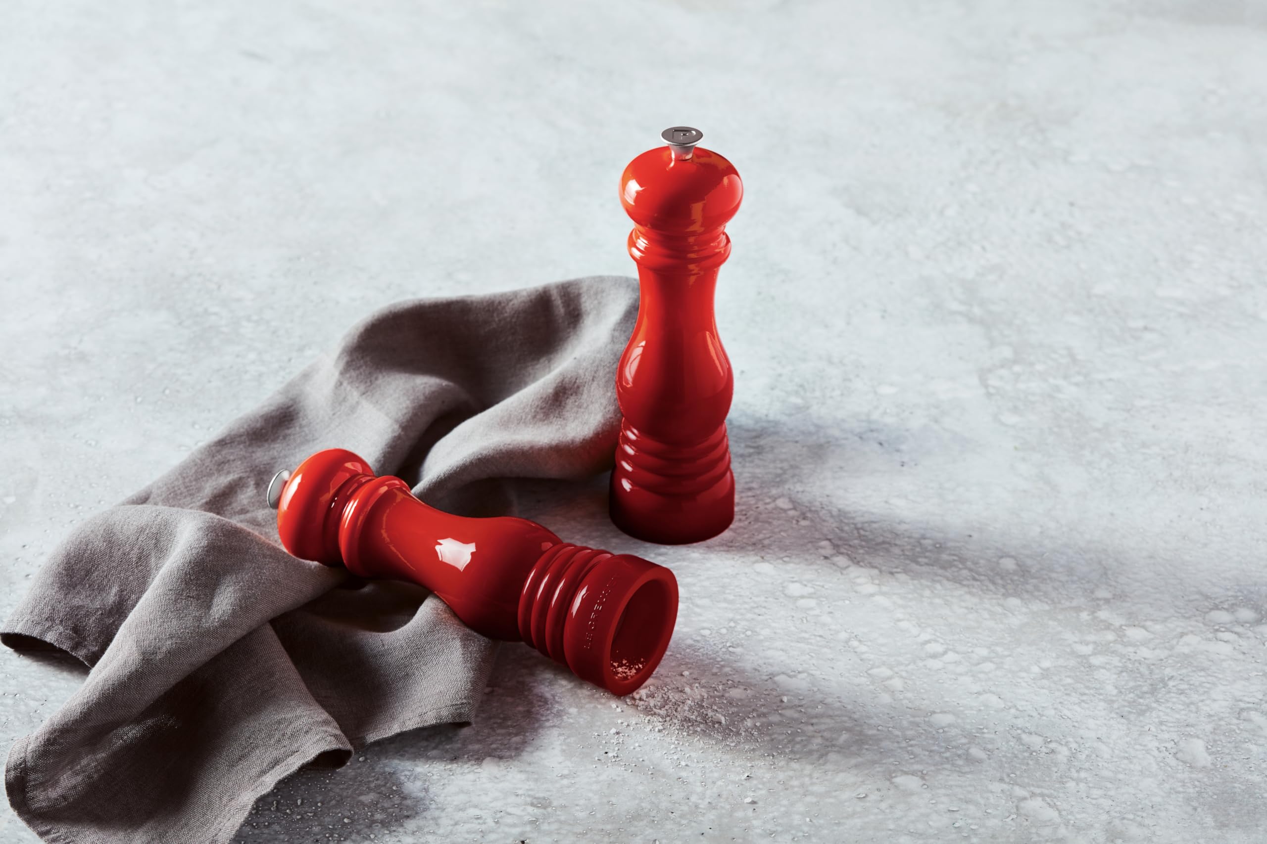 Cerise Le Creuset mills on a countertop add color while preserving freshness
