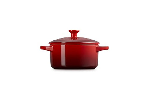 Le Creuset Cerise cocotte serving hot portions at the table.