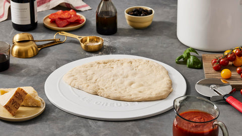 Le Creuset stoneware pizza stone shown from oven to table