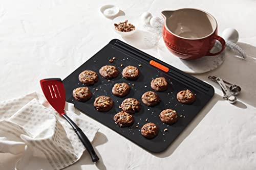 Le Creuset Revolution bi-material spatula head close-up emphasizes flexible edge for delicate flipping.