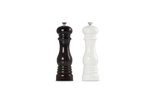Le Creuset salt and pepper mills set on a dining table.