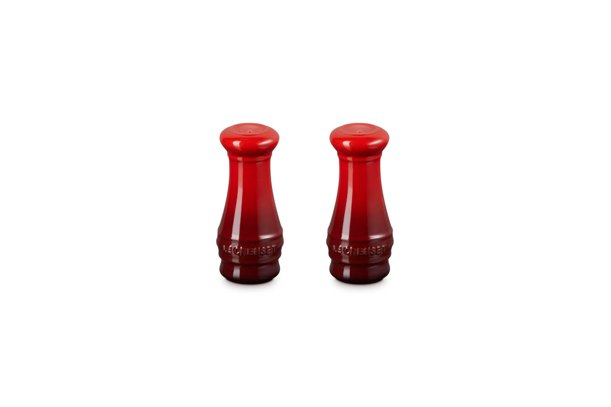 Le Creuset salt and pepper shakers in Cerise on a table for everyday seasoning