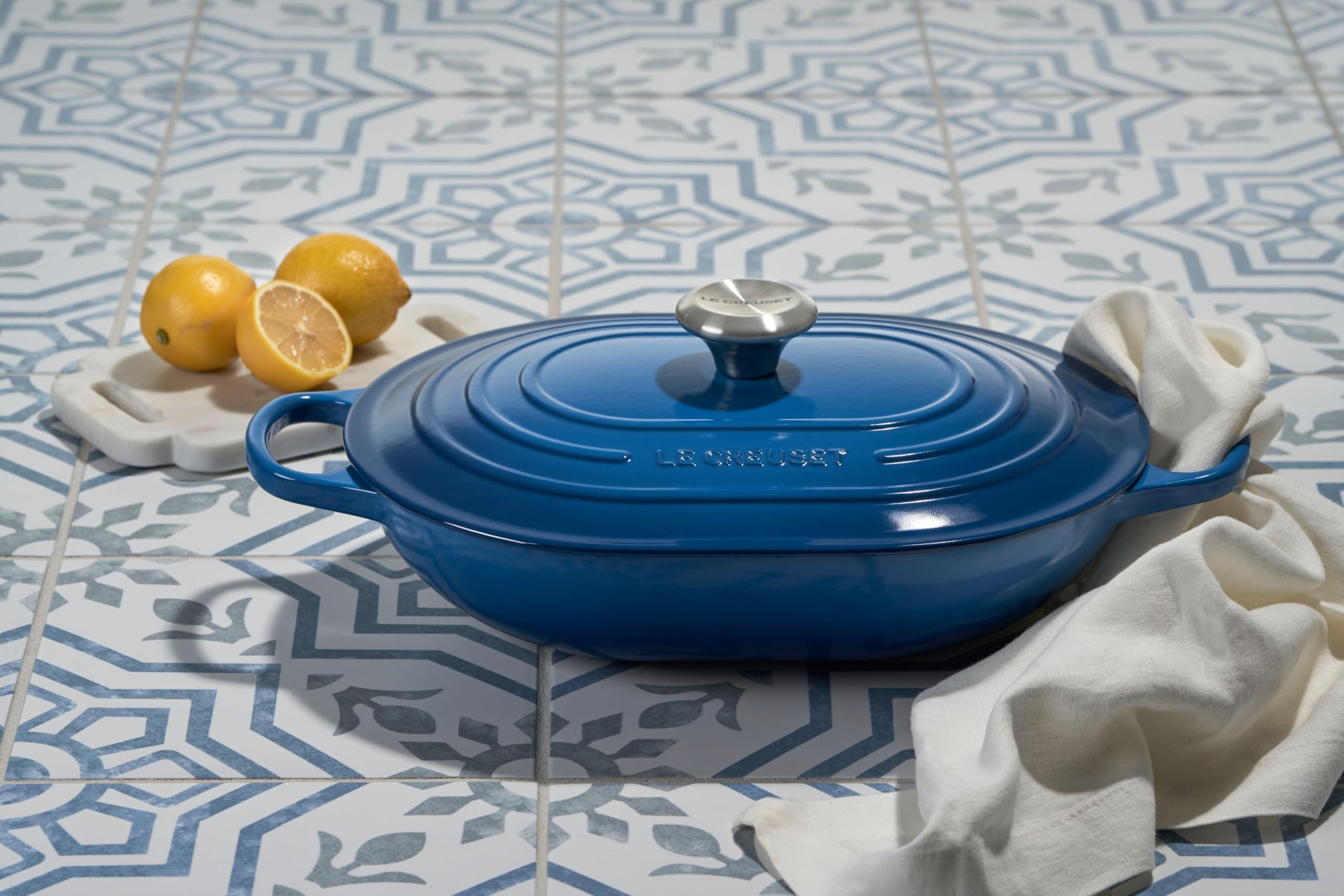 Le Creuset olive oval casserole ready for sharing dishes at table.