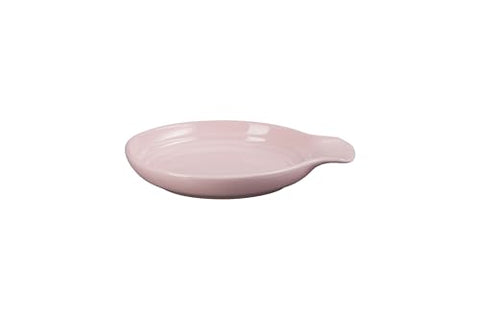 Le Creuset round spoon rest on a table setting keeps serving utensils tidy.