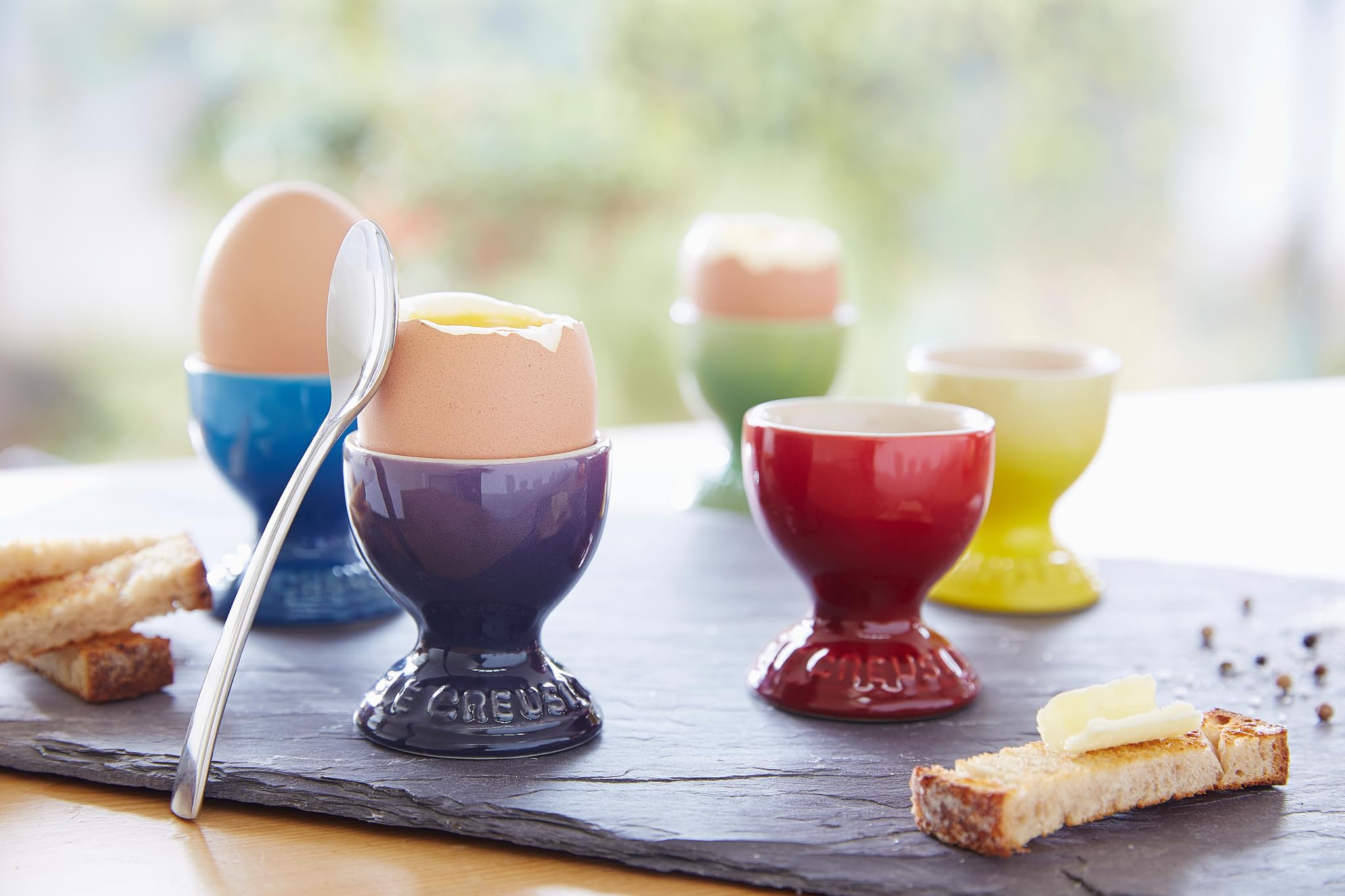 Le Creuset Egg Cup Flame on table with herbs, decorative yet functional