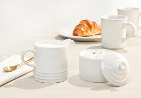 Le Creuset stoneware mugs 4 white complete set arranged for display.