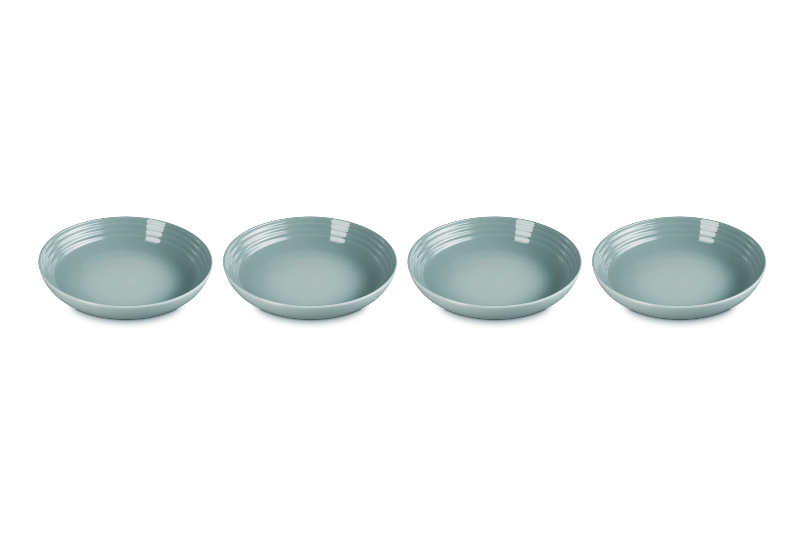 Le Creuset stoneware pasta bowls in Sea Salt, four-piece set ideal for pasta dinners.