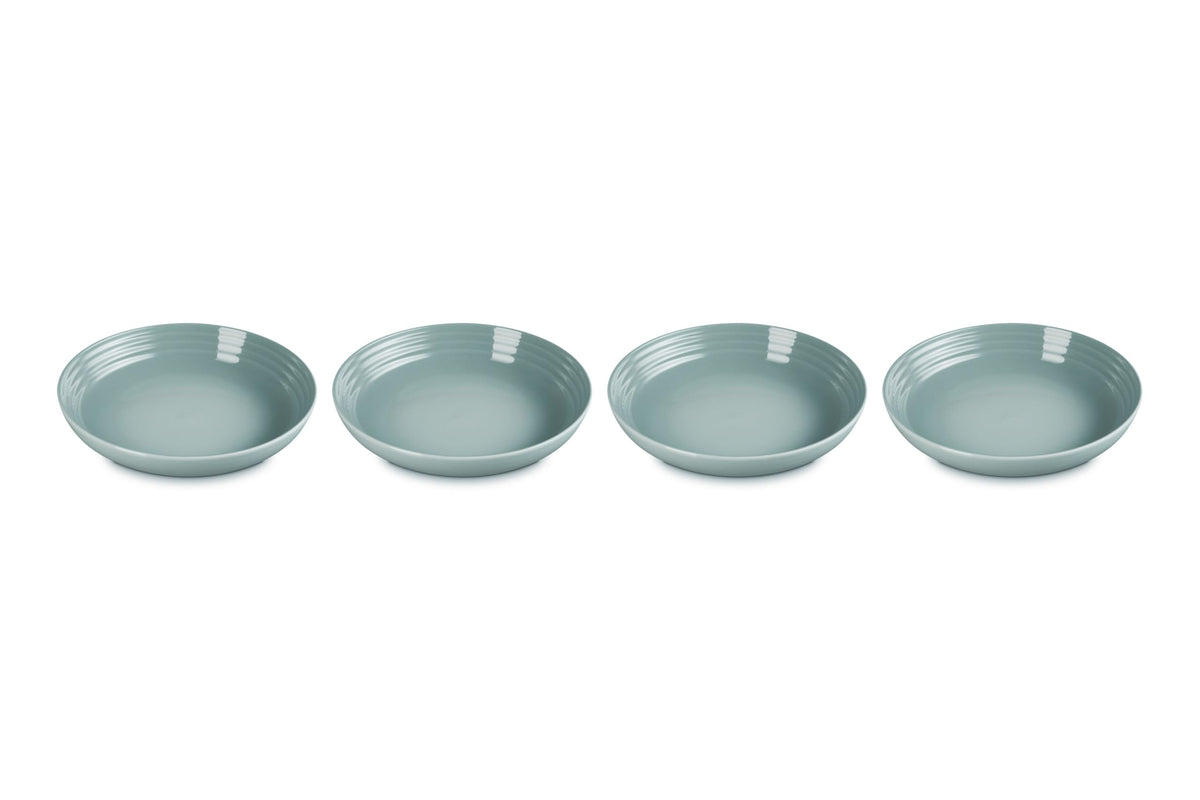 Le Creuset stoneware pasta bowls in Sea Salt, four-piece set ideal for pasta dinners.
