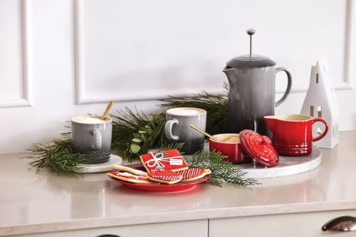 Le Creuset stoneware set displayed on a kitchen counter in Cerise
