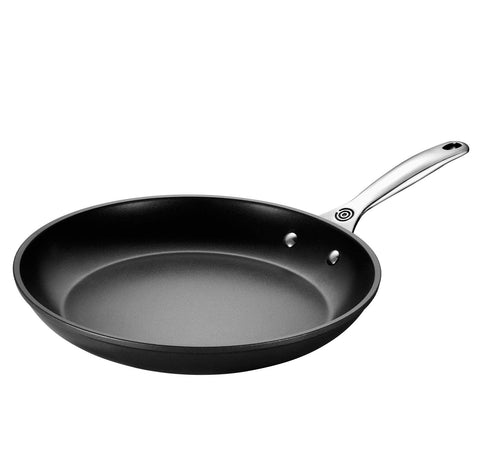 Le Creuset tempered glass lid compatible up to 425°F for controlled cooking.