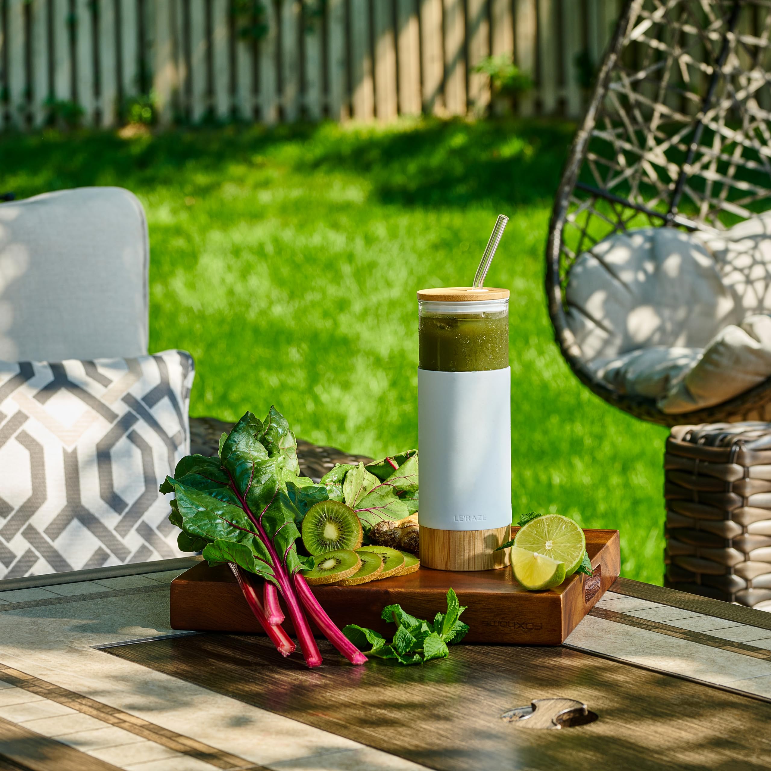 Le'raze glass tumbler with straw and bamboo lid for convenient sipping.