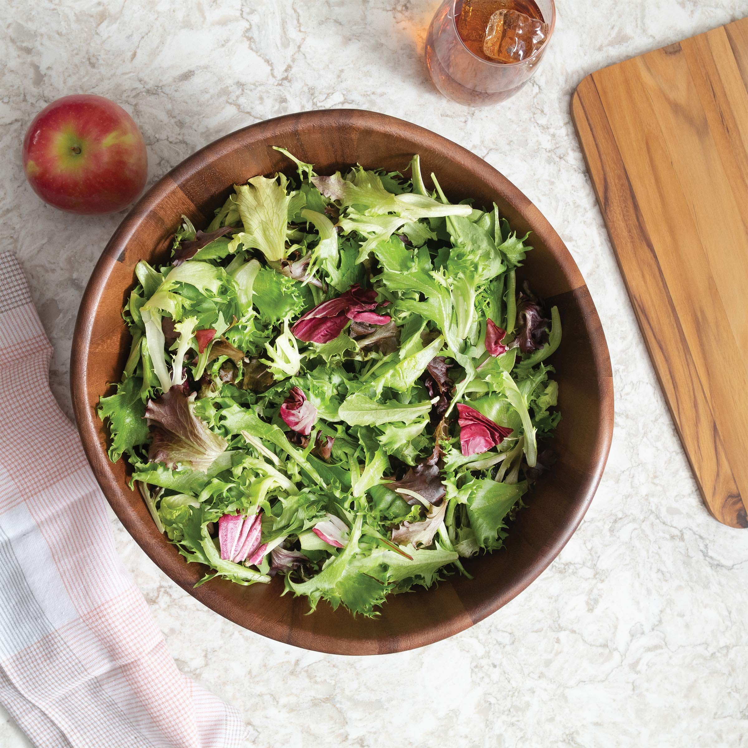 Salad being tossed and served in the acacia wave bowl.