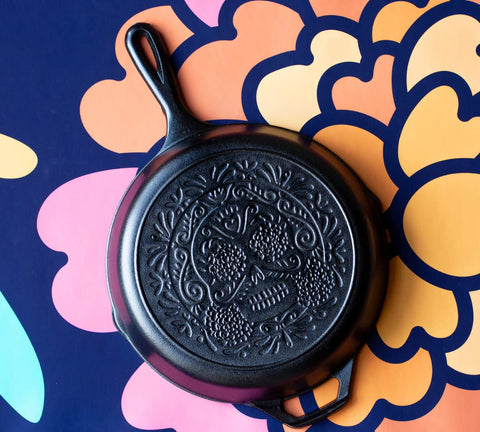 Lodge Sugar Skull skillet over campfire for outdoor cooking.