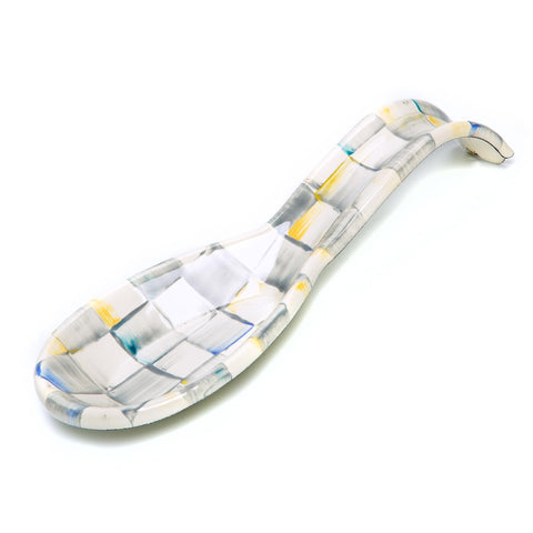 MACKENZIE-CHILDS enamel spoon rest on stovetop with grey-check pattern keeps counters tidy.