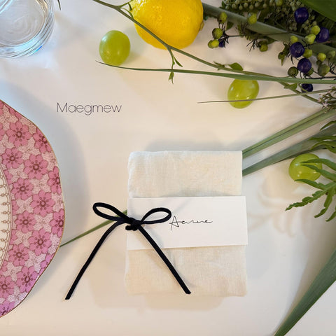 Elegant table setting featuring Maegmew velvet ribbon and black placards.