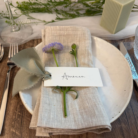 Maegmew table name cards in dusty green enhance event decor and organization.