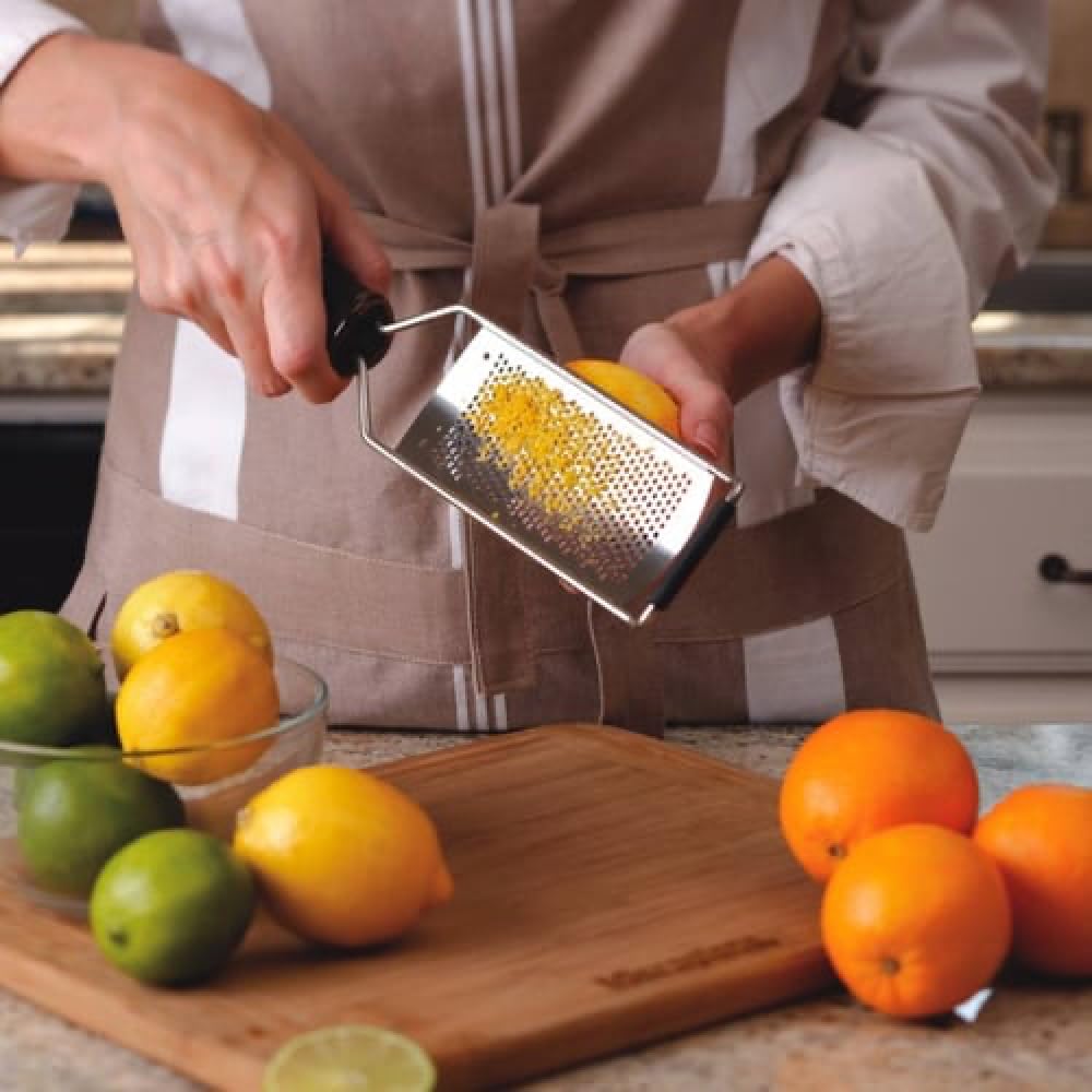 Microplane Gourmet Series grater grates cheese over pasta for even coating.
