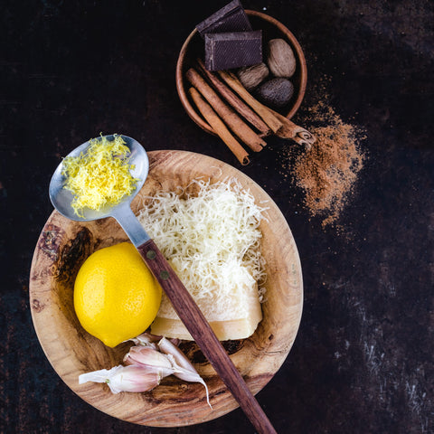 Microplane Home Series grater producing powdery citrus zest and cheese shavings.