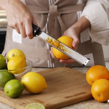 Microplane Premium Classic zester close-up with eggplant purple handle, showcasing USA-made blade for precise zesting.