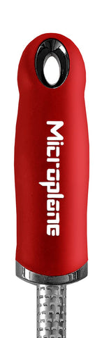 Microplane red spice grater creates aromatic cinnamon shavings for desserts.