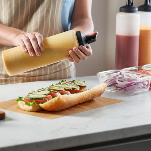 MIGHTY STRONG squeeze bottle in kitchen setting for sauces on the table