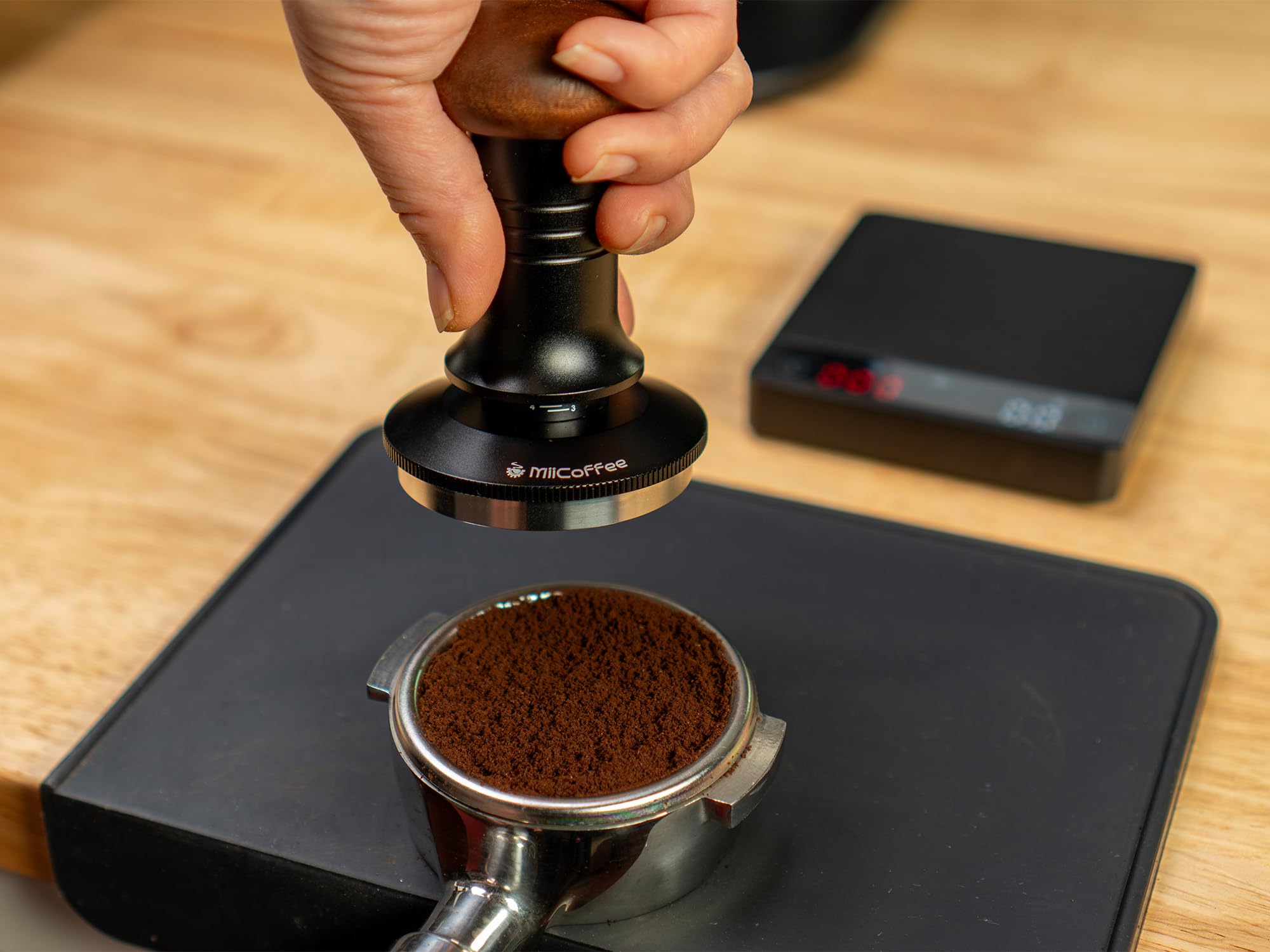 MiiCoffee ergonomic handle blends wood and metal for comfortable tamping.