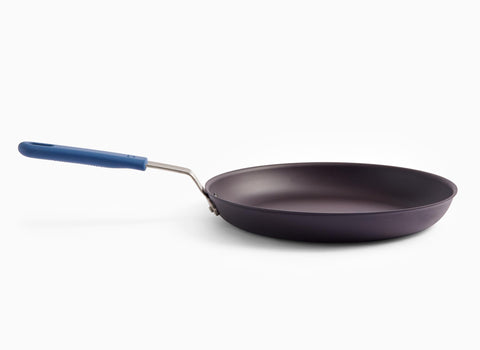 Misen 12-inch carbon steel fry pan on a stove showing even heat for searing and sautéing.