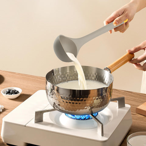 MOACC slotted spoon demonstrates gentle contact with coated cookware to prevent scratches.