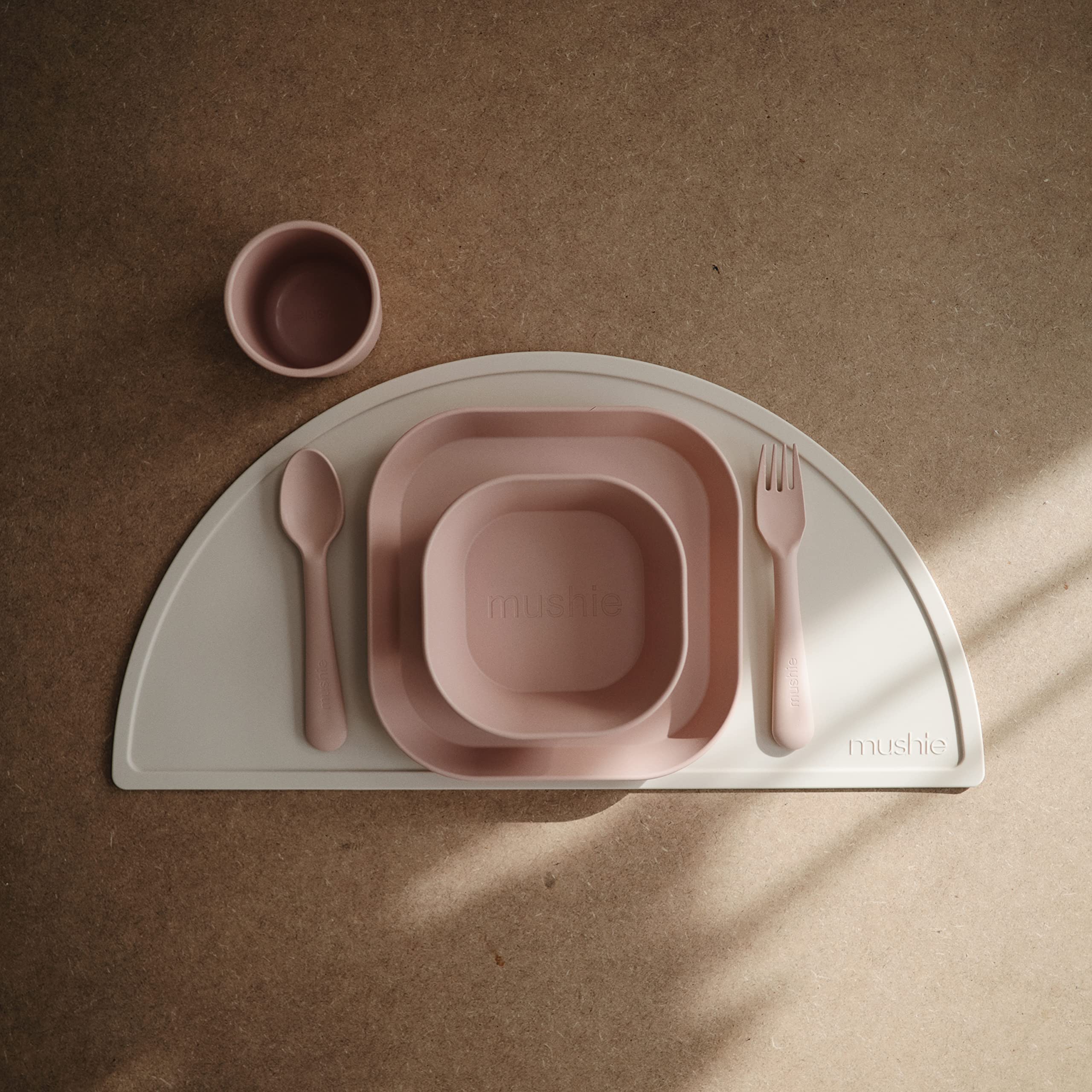 Two Mushie blush plates stacked together, compact storage for small kitchens.