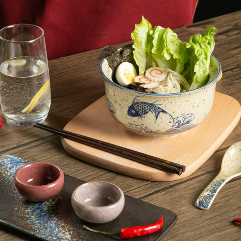Niturceal spoons and chopsticks accompany bowls for a complete setting.