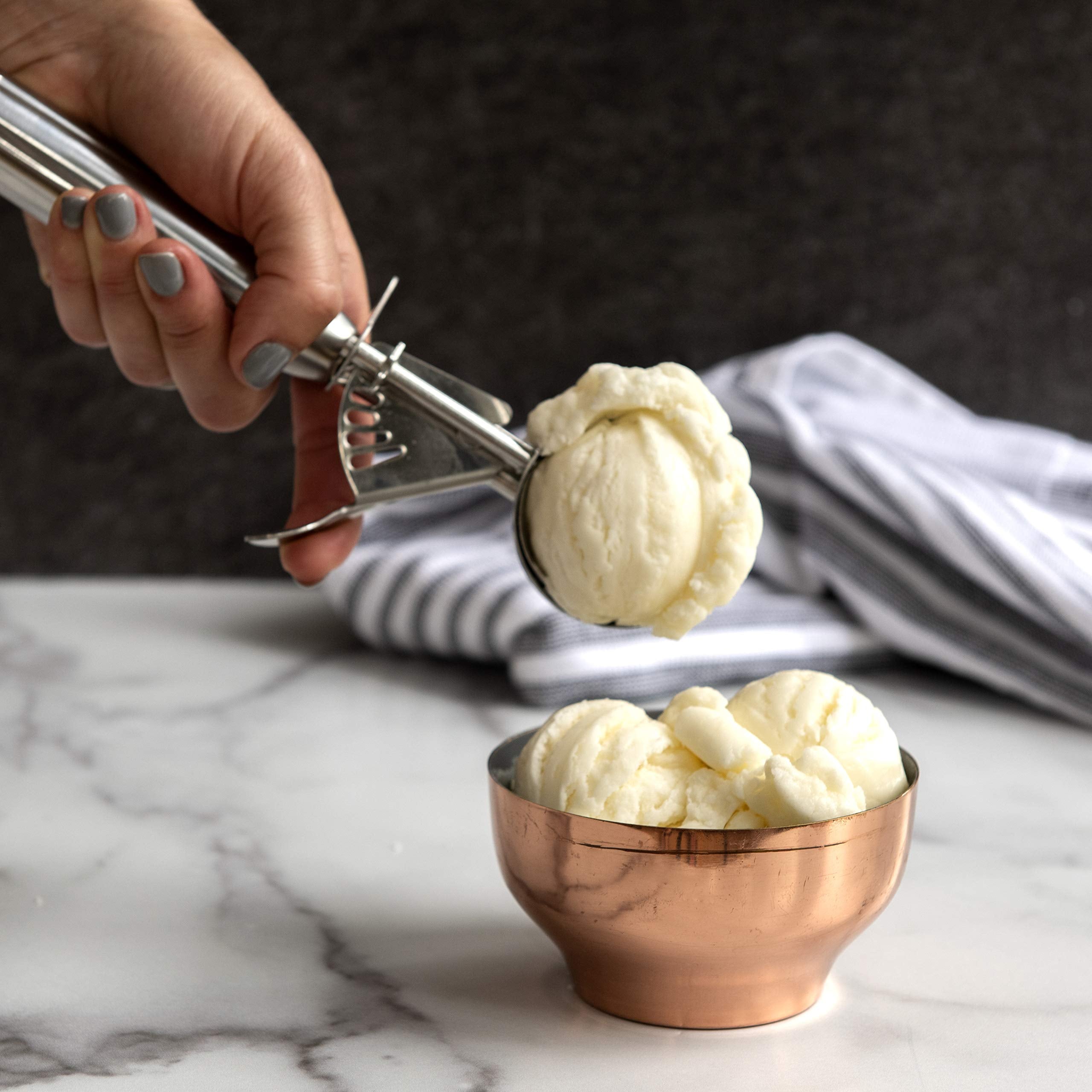 Nordic Ware cookie scoop portioning batter into muffins for even bake sizes.