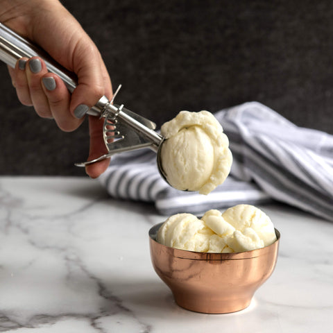 Nordic Ware cookie scoop portioning batter into muffins for even bake sizes.