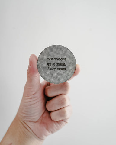 Normcore puck screen being rinsed for quick cleaning and maintenance