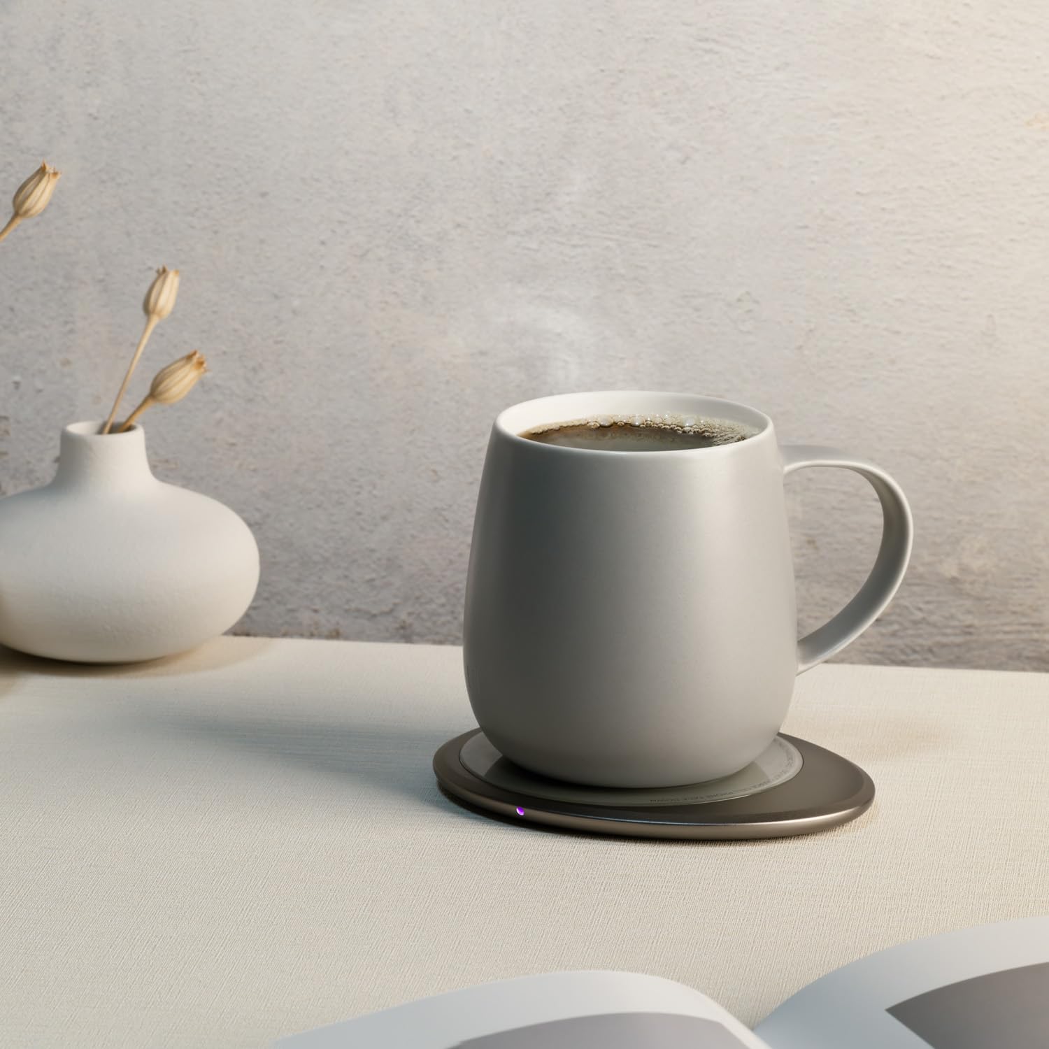 OHOM Ui3 mug resting on the wireless charging pad while heating the beverage