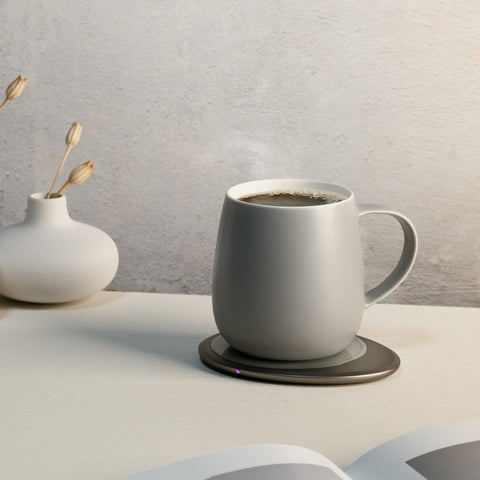 OHOM Ui3 mug resting on the wireless charging pad while heating the beverage