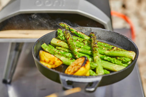 Ooni skillet shown with pizza oven accessories for outdoor cooking.